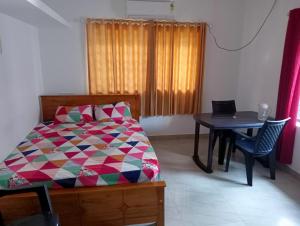 a bedroom with a bed and a table with chairs at MALANAD GUEST HOUSE THENGIPALAM CHENAKAL UNIVERCITY ROAD 