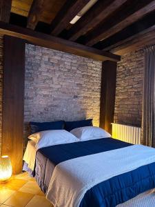 Ce lit se trouve dans une chambre dotée d'un mur en briques. dans l'établissement Ca Giobbe, à Venise