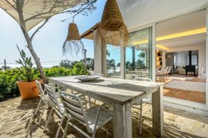 a dining room with a wooden table and chairs at Cala Salada Sunset View in San Antonio