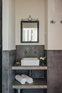 La salle de bains est pourvue d'un lavabo et d'un miroir. dans l'établissement Apricus Locanda Boutique Hotel, à Apricale