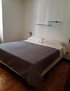 een groot bed in een kamer met een witte muur bij APPARTAMENTO MIRTA in Molina di Ledro