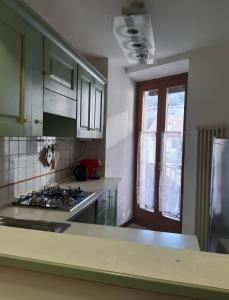 cocina con fogones horno superior junto a una ventana en APPARTAMENTO MIRTA, en Molina di Ledro