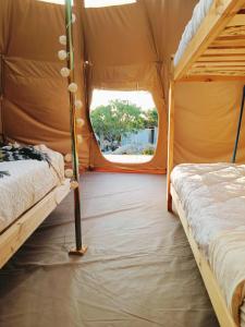 dwa łóżka w namiocie z oknem w obiekcie aGlampar Toto Península Beach w mieście Coquimbo