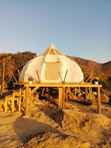 a tent on a wooden table in the desert at aGlampar Toto Península Beach in Coquimbo