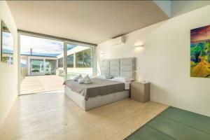 ein Schlafzimmer mit einem Bett und einem großen Fenster in der Unterkunft Seafront Villa Sunset Alcudia in Alcúdia