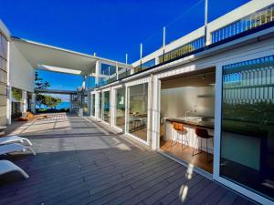eine offene Terrasse eines Hauses mit einem Tisch und Stühlen in der Unterkunft Seafront Villa Sunset Alcudia in Alcúdia