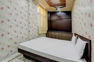 um pequeno quarto com uma cama e uma janela em OYO 82032 The Gunjan Villa Palace em Udaipur