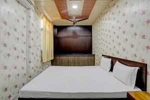 um pequeno quarto com uma cama num quarto em OYO 82032 The Gunjan Villa Palace em Udaipur