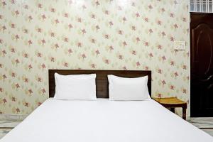 uma cama com duas almofadas brancas num quarto em OYO 82032 The Gunjan Villa Palace em Udaipur