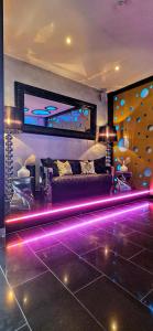 a living room with a couch and purple lights at Hotel Platin in Regensburg
