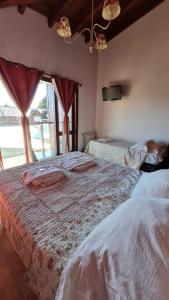 una camera con due letti e una grande finestra di Complejo Raíces Patagonicas a Dina Huapi
