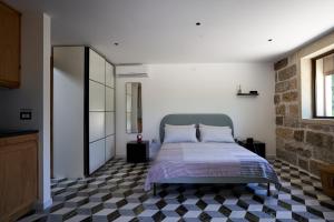ein Schlafzimmer mit einem Bett und einem karierten Boden in der Unterkunft Il Cubetto- a cute mini house in olive grove in Surano