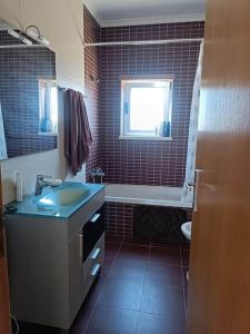 La salle de bains est pourvue d'un lavabo, d'une baignoire et d'une fenêtre. dans l'établissement Holiday HouseV5 W/Pool & BBQ, à Albufeira