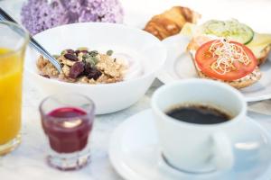 uma mesa coberta com pratos de comida e uma chávena de café em Ludvika Stadshotell em Ludvika