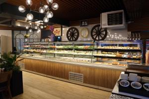 a bakery with a display case filled with pastries at Mihman Hotel in Tuzla