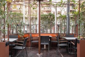 a restaurant with tables and chairs and trees at Hotel Madanis in Hospitalet de Llobregat