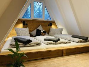 uma cama grande com almofadas no sótão em Nurdachhaus Sauerland em Kirchhundem