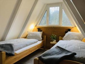 2 camas en una habitación con ventana en Nurdachhaus Sauerland en Kirchhundem