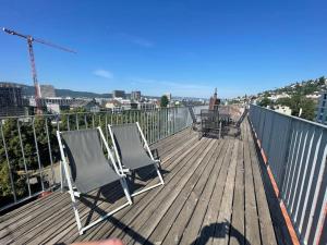 eine Terrasse mit zwei Stühlen und einem Tisch darauf in der Unterkunft Zürich 3 Zimmer Wohnung mit Dachterrasse in Zürich