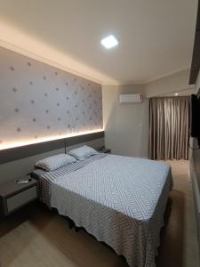 a bedroom with a large bed and a wall at Vista mar com ótima localização na meia praia in Itapema +9 photos