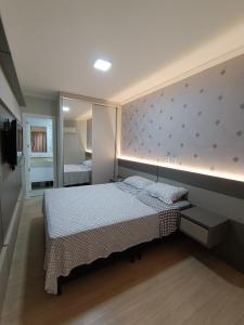 a bedroom with a large bed and a mirror at Vista mar com ótima localização na meia praia in Itapema
