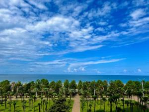 park z drzewami i oceanem w tle w obiekcie Bellevue Residence Suites w mieście Batumi