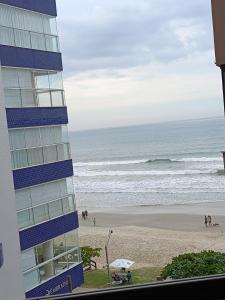 a view of the beach from the balcony of a building at Vista mar com ótima localização na meia praia in Itapema