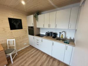 a kitchen with white cabinets and a sink and a table at TinyHaus #1 Hülben - Ortsrand - kostenlose Parkplätze in Hülben