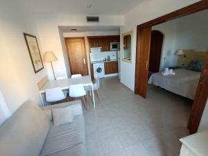 een woonkamer en een keuken met een bank en een tafel bij APARTAMENTO EN SEGUNDA PLANTA EN URB. JARDINES DE ISLA CANELA in Ayamonte
