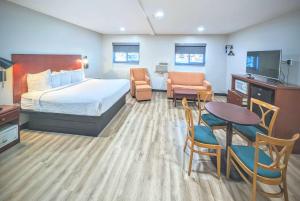 pokój hotelowy z łóżkiem, stołem i krzesłami w obiekcie Days Inn by Wyndham Flagstaff I-40 w mieście Flagstaff