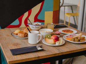 een houten tafel met borden eten erop bij Mercure Le Havre Centre Bassin Du Commerce in Le Havre