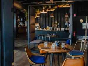 una sala da pranzo con tavolo e sedie in legno di Mercure Le Havre Centre Bassin Du Commerce a Le Havre