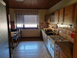 cocina con armarios de madera, mesa y ventana en Skala en Rečica ob Savinji