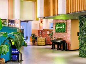 a restaurant with a grand piano in the lobby at Novotel London Greenwich in London