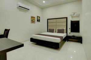 a bedroom with a bed and a television in it at Ovel Hotel Grand in Ābādpura