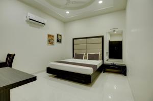 a bedroom with a bed and a television in it at Ovel Hotel Grand in Ābādpura