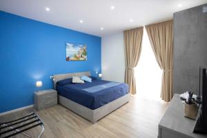 a blue bedroom with a bed and a blue wall at GIULY SUITES & ROOMS in Naples