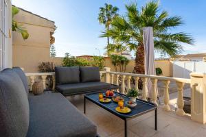 eine Terrasse mit einem Sofa und einem Tisch auf dem Balkon in der Unterkunft Charming House with private pool in urb saint Louis in Torrevieja