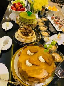 a table with several cakes and plates of food at The Plaza Hotel & Resort in Salalah