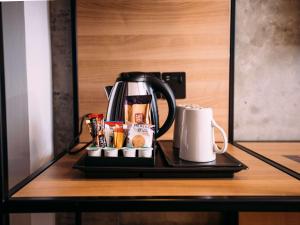 eine Kaffeekanne und eine Tasse auf dem Tisch in der Unterkunft ibis Belfast City Centre in Belfast