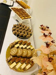 a table with several trays of cookies and other desserts at The Plaza Hotel & Resort in Salalah