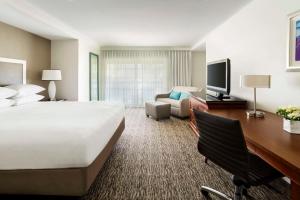 een grote hotelkamer met een groot bed en een bureau bij Hyatt Regency Newport Beach in Newport Beach