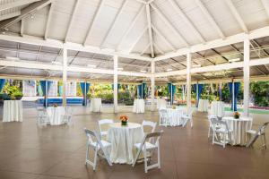 - une salle de banquet avec des tables et des chaises blanches dans l'établissement Hyatt Regency Newport Beach, à Newport Beach