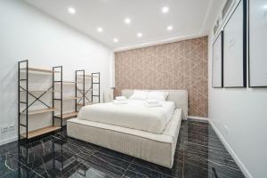ein Schlafzimmer mit einem großen weißen Bett und Regalen in der Unterkunft Appartement Mairie des Lilas - III in Les Lilas