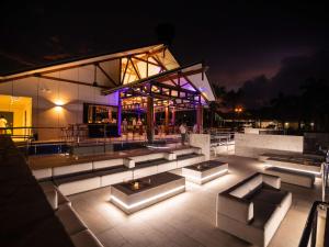 un patio éclairé avec des canapés et un bâtiment la nuit dans l'établissement Mercure Darwin Airport Resort, à Darwin