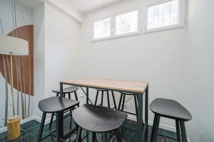 einen Tisch und vier Hocker in einem Zimmer in der Unterkunft Appartement Mairie des Lilas - III in Les Lilas