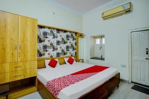 Hotel O Dayal Heritage في Hazārībāg: غرفة نوم بسرير كبير مع وسائد حمراء +20 صورة