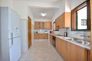 cocina grande con armarios de madera y fregadero en Close to amenities, free air conditioning and wi-fi, en Quarteira