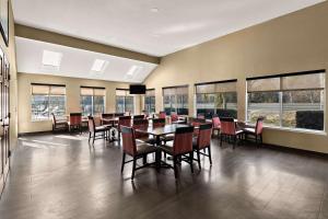 a dining room with a table and chairs and windows at Comfort Inn & Suites Sequoia Kings Canyon in Three Rivers