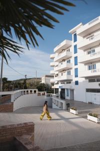 une femme marchant devant un bâtiment dans l'établissement CAPTAIN'S RESIDENCE, à Ksamil